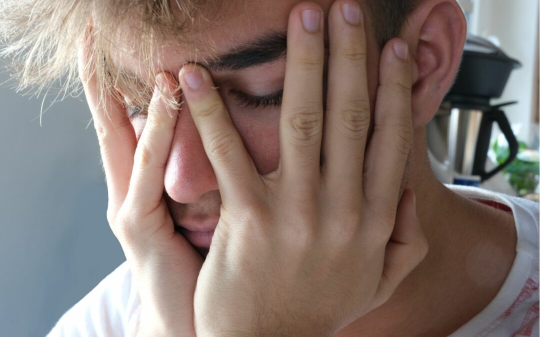 jeune homme le visage entre ses mains