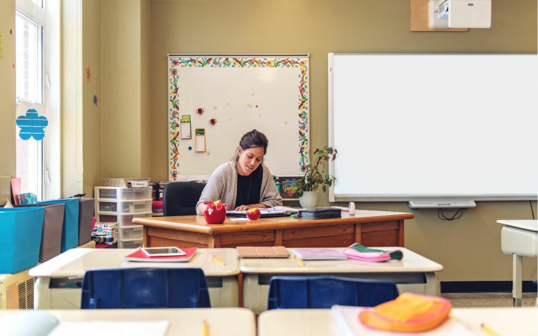 enseignante qui corrige des devoirs dans une classe