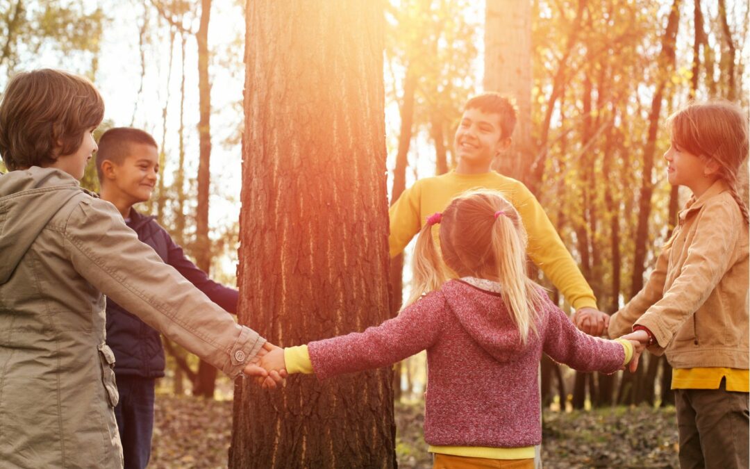 Enfants qui font la ronde autour d'un tronc d'arbre