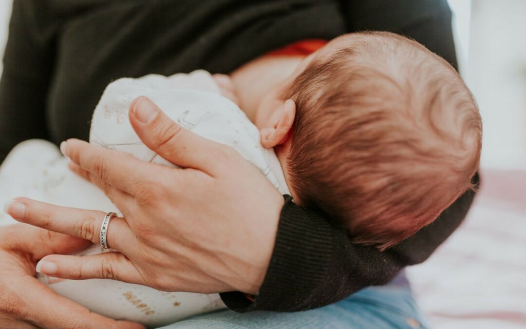 Un bébé nourri au sein par sa mère