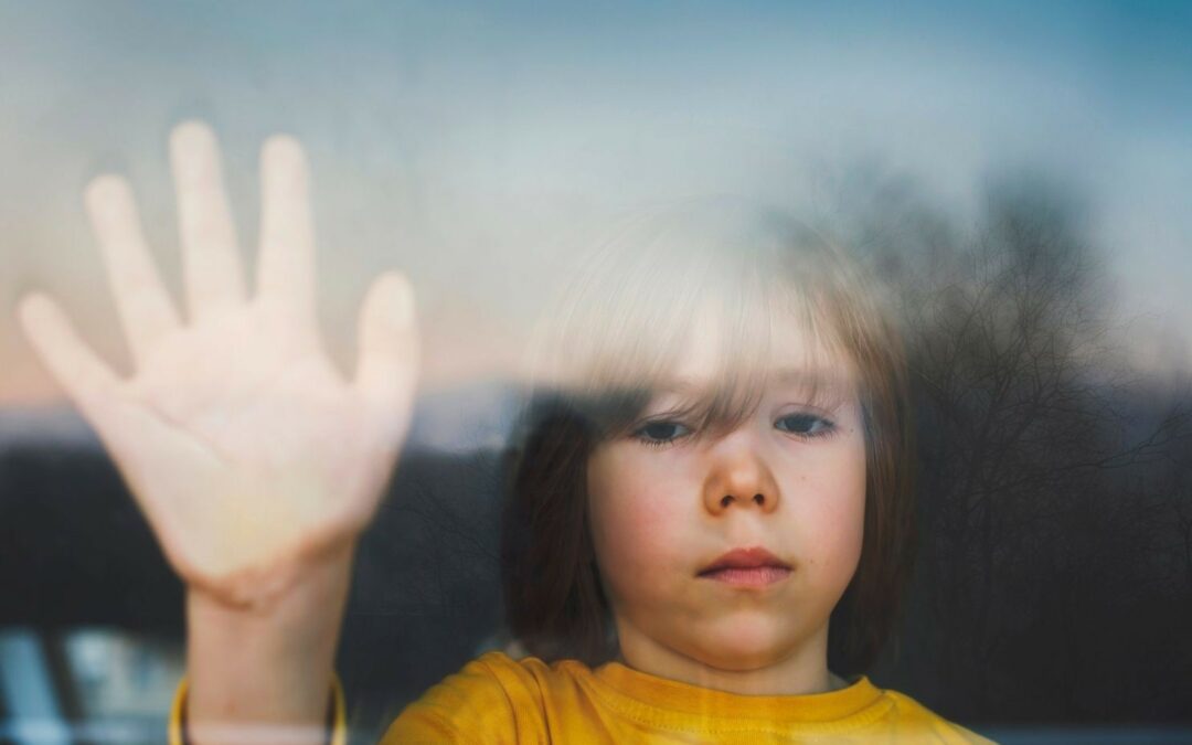 placement d'enfants un enfant triste et apeuré colle sa main derrière une vitre